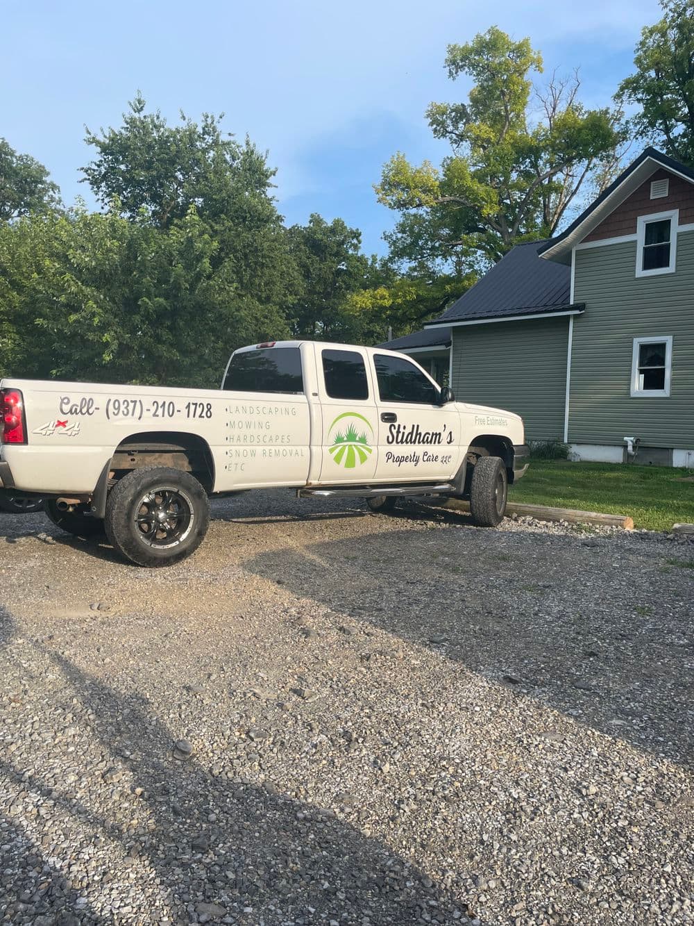 Stidham's Property Care truck parked beside a house, offering landscaping and lawn care services.